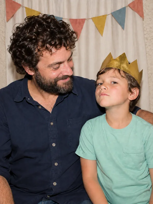 Dad and son with a paper crown in a Los Angeles photobooth
