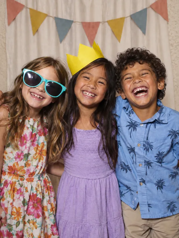 Kids birthday photobooth LA - friends laughing in party props