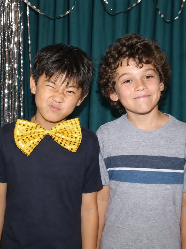 Kids goofing around with a gold bowtie at an LA photobooth