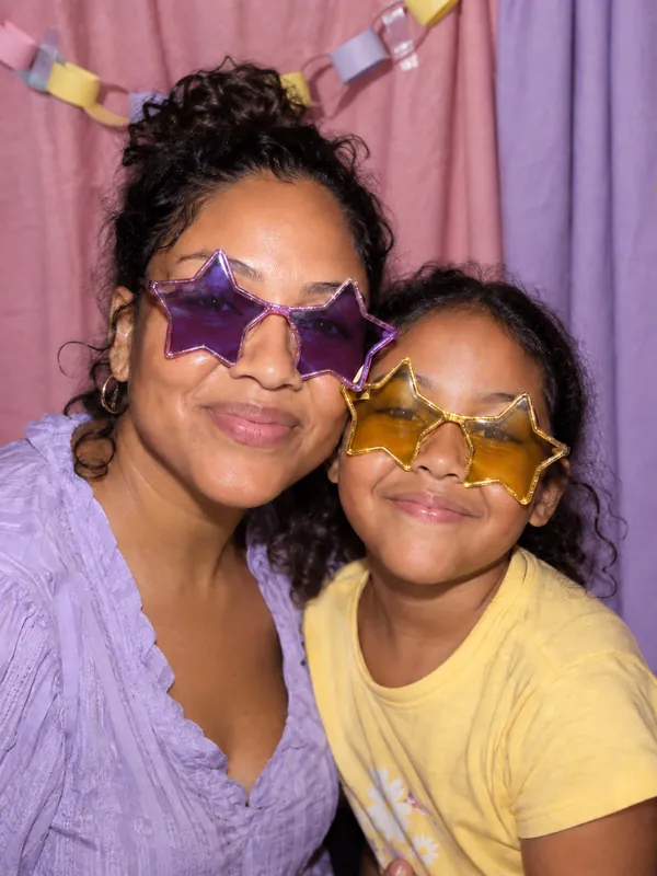 Mother and daughter in star glasses at an LA photobooth